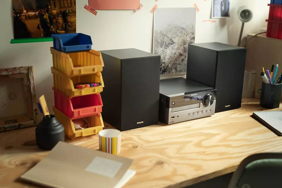 System stereo z głośnikami i biurko z przedmiotami na nim.