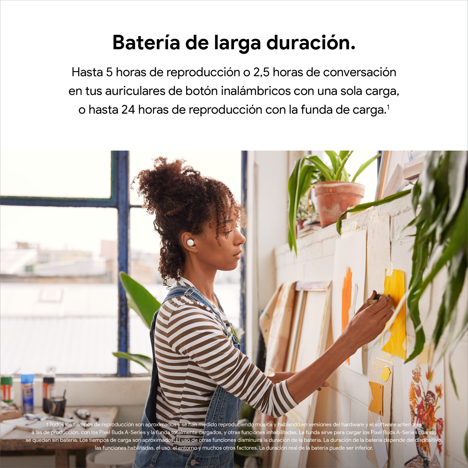 Mujer con auriculares, pintando en una pared con notas adhesivas amarillas, usando un top a rayas y overoles de mezclilla.