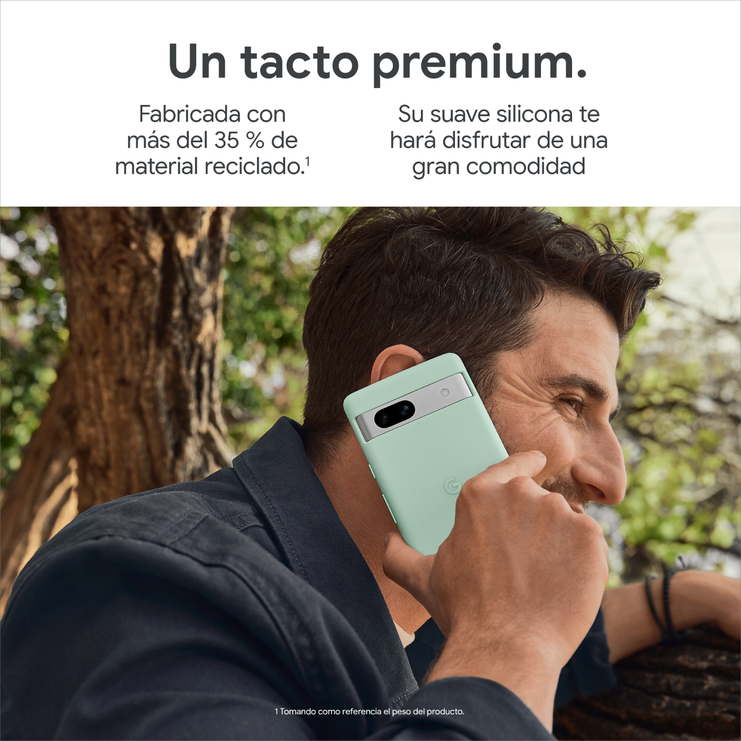 Un hombre sosteniendo un teléfono menta, cerca de un árbol. Está sonriendo. La funda es verde.