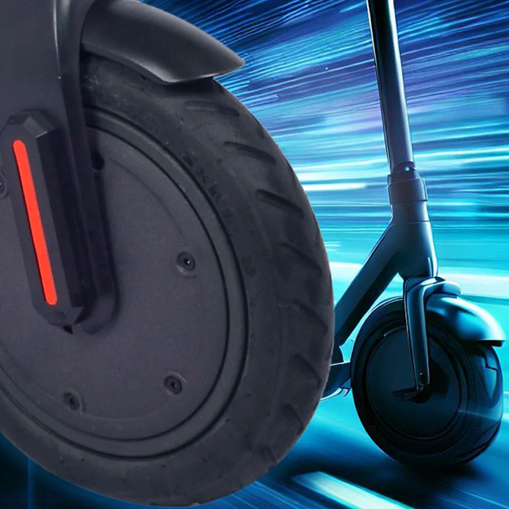 Zbliżenie na koło hulajnogi elektrycznej i część nadwozia. Czarne koło, pomarańczowy pasek i część nadwozia.