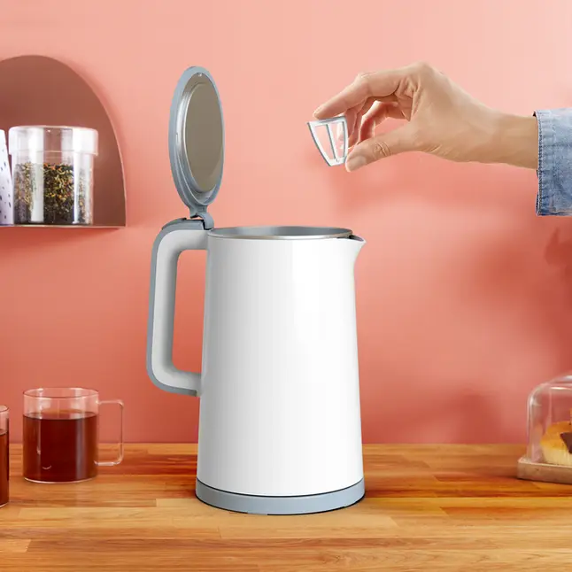 Biały czajnik z ręką wkładającą filtr do góry.