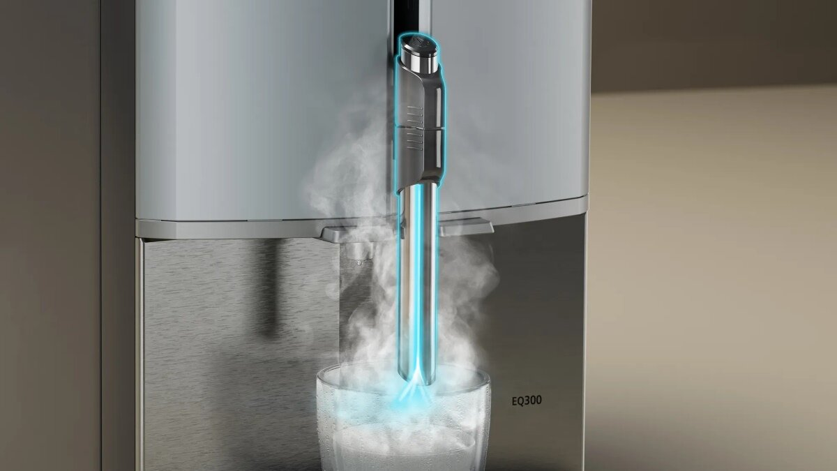 Srebrny dystrybutor wody z parą wydobywającą się z dyszy.