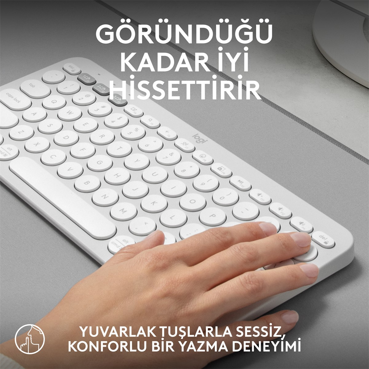 Yuvarlak tuşlu beyaz klavye ve üzerinde yazan bir el.