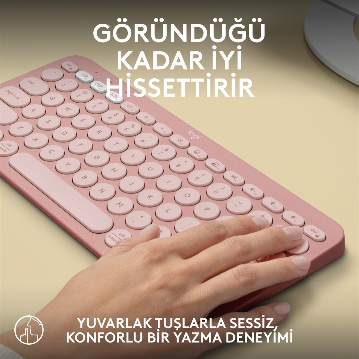 Pembe kablosuz klavye, yazan bir elle. Klavye yuvarlak tuşlara sahip.