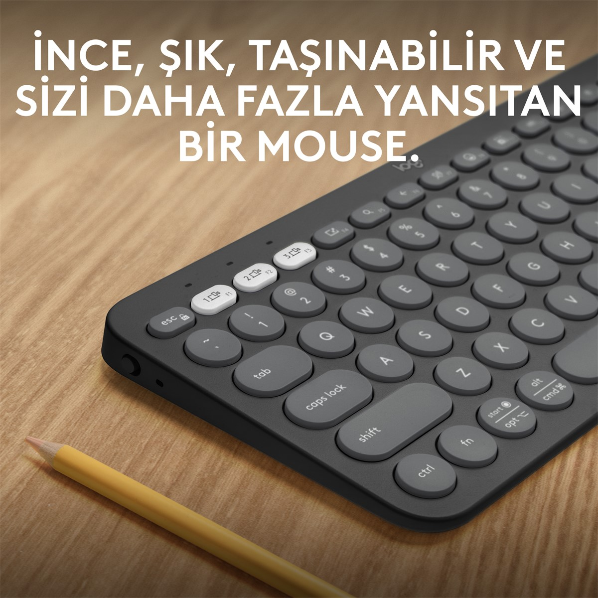 Gri tuşlu koyu renk bir klavye ve sarı bir kalem. Arka plan ahşap bir masa.