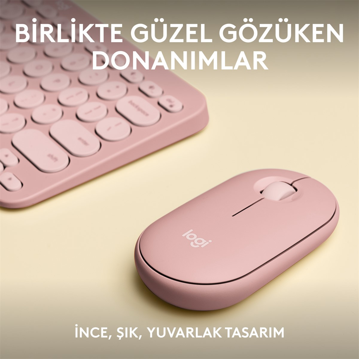 Açık sarı bir yüzey üzerinde pembe klavye ve fare. Türkçe metin. Yakın çekim.
