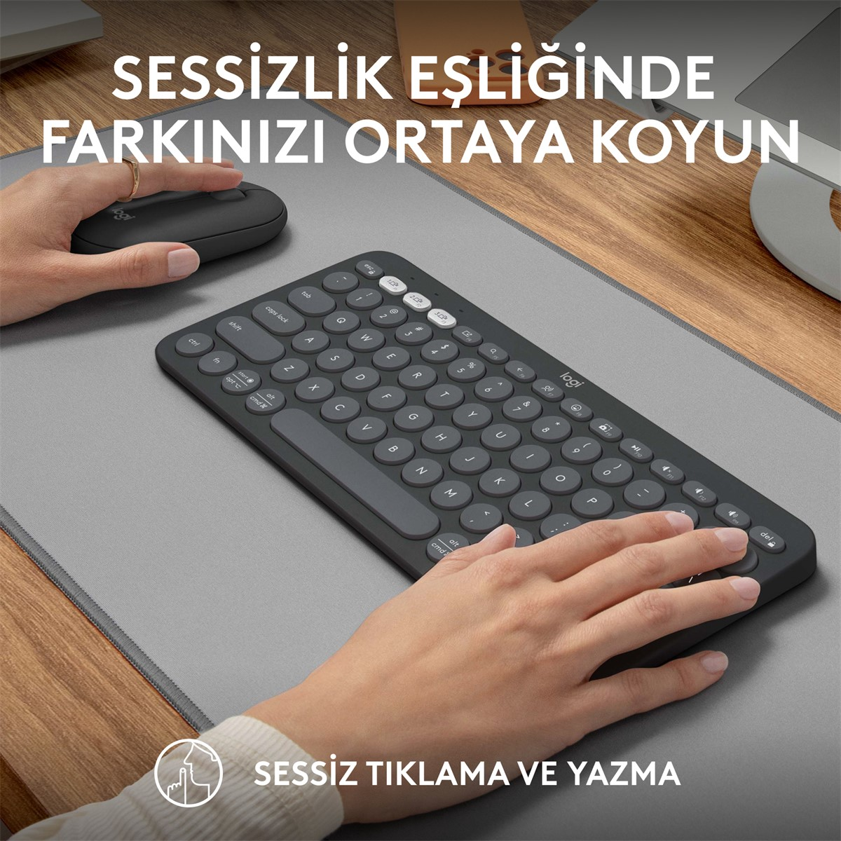 Bir kişi gri bir mousepad üzerinde klavye ve fare kullanıyor. Türkçe metin görülüyor.