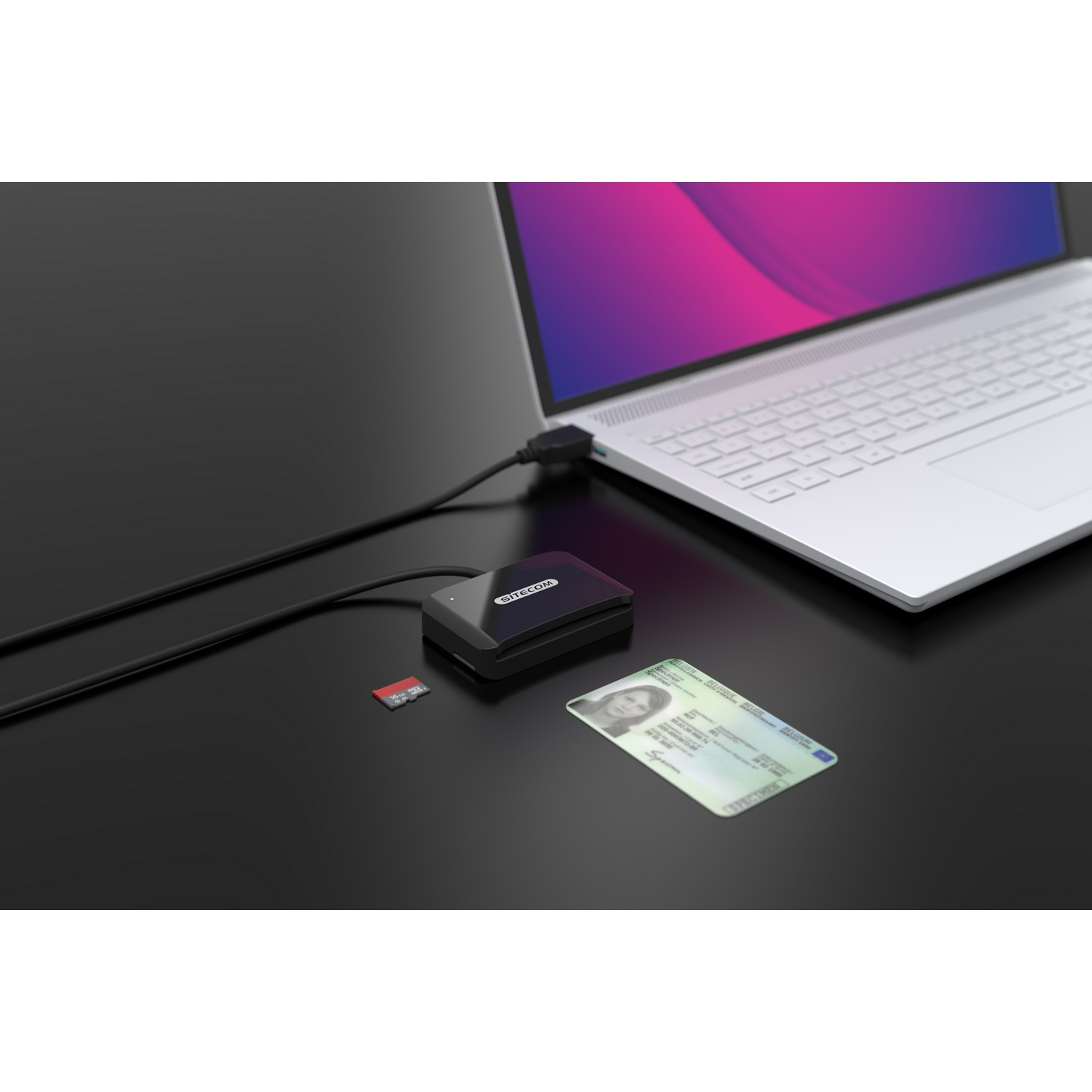 A black card reader connected to a laptop, with an ID card and a SD card.