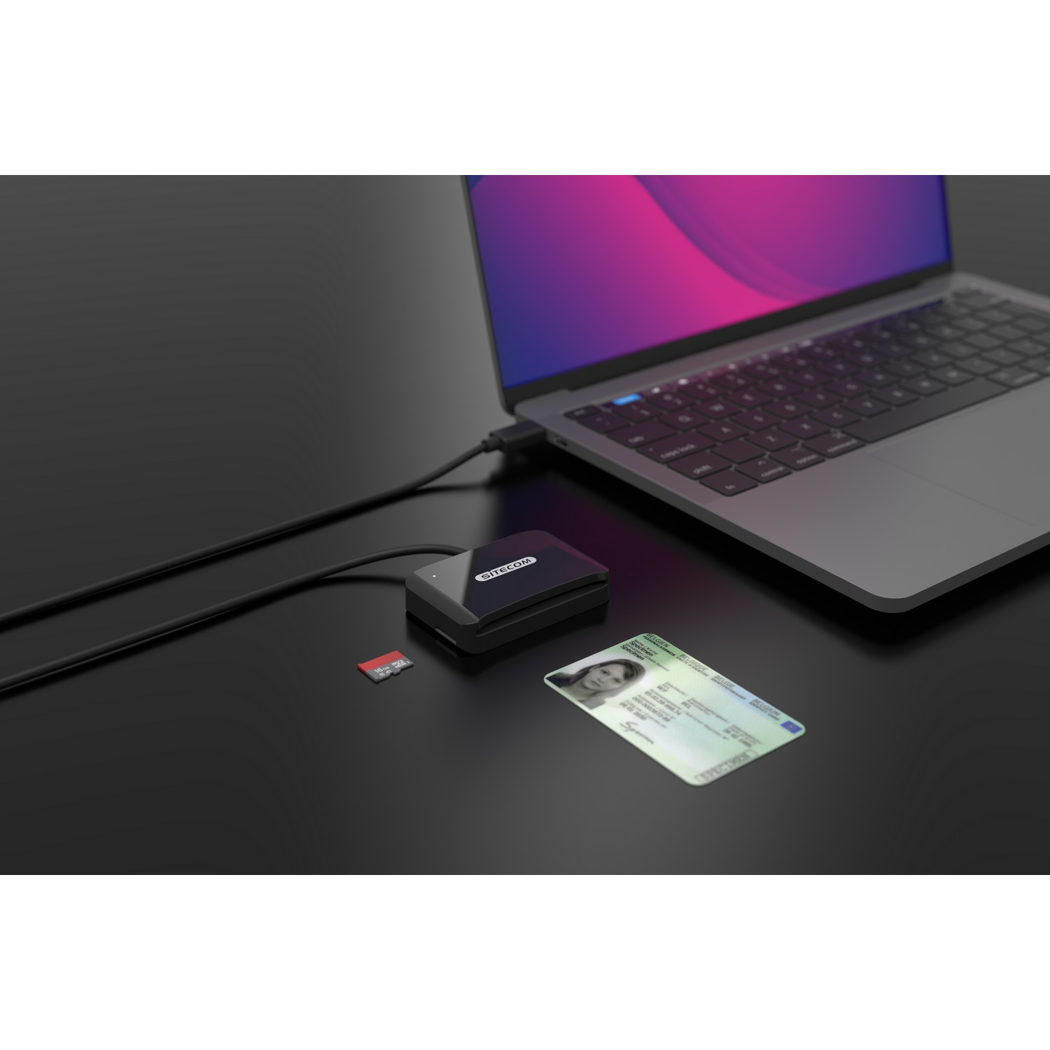 Laptop, card reader, ID card, and SD card on a black surface. Connected to the laptop.