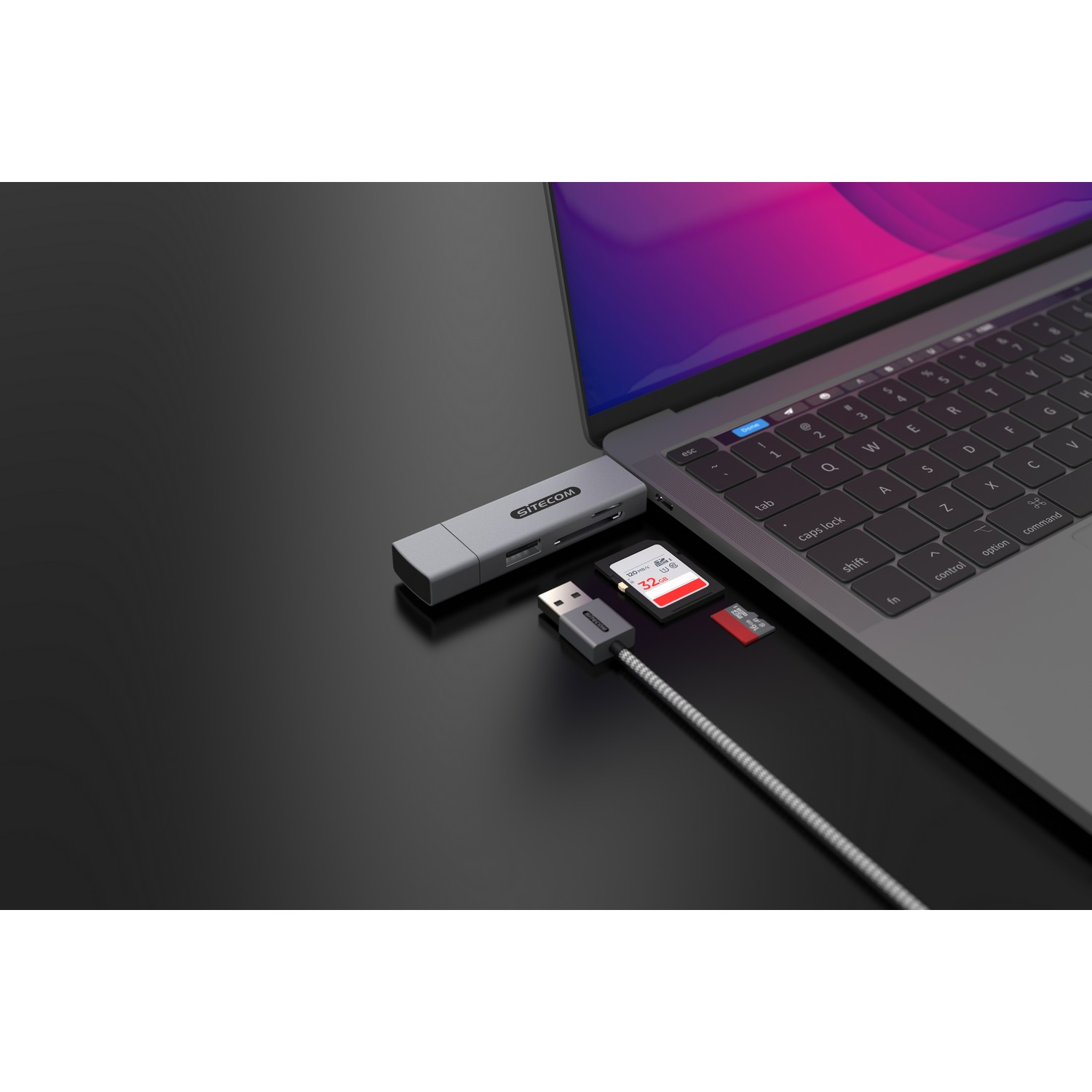 Ordinateur portable avec un hub USB-C et des appareils connectés : carte SD, carte Micro SD et câble USB.