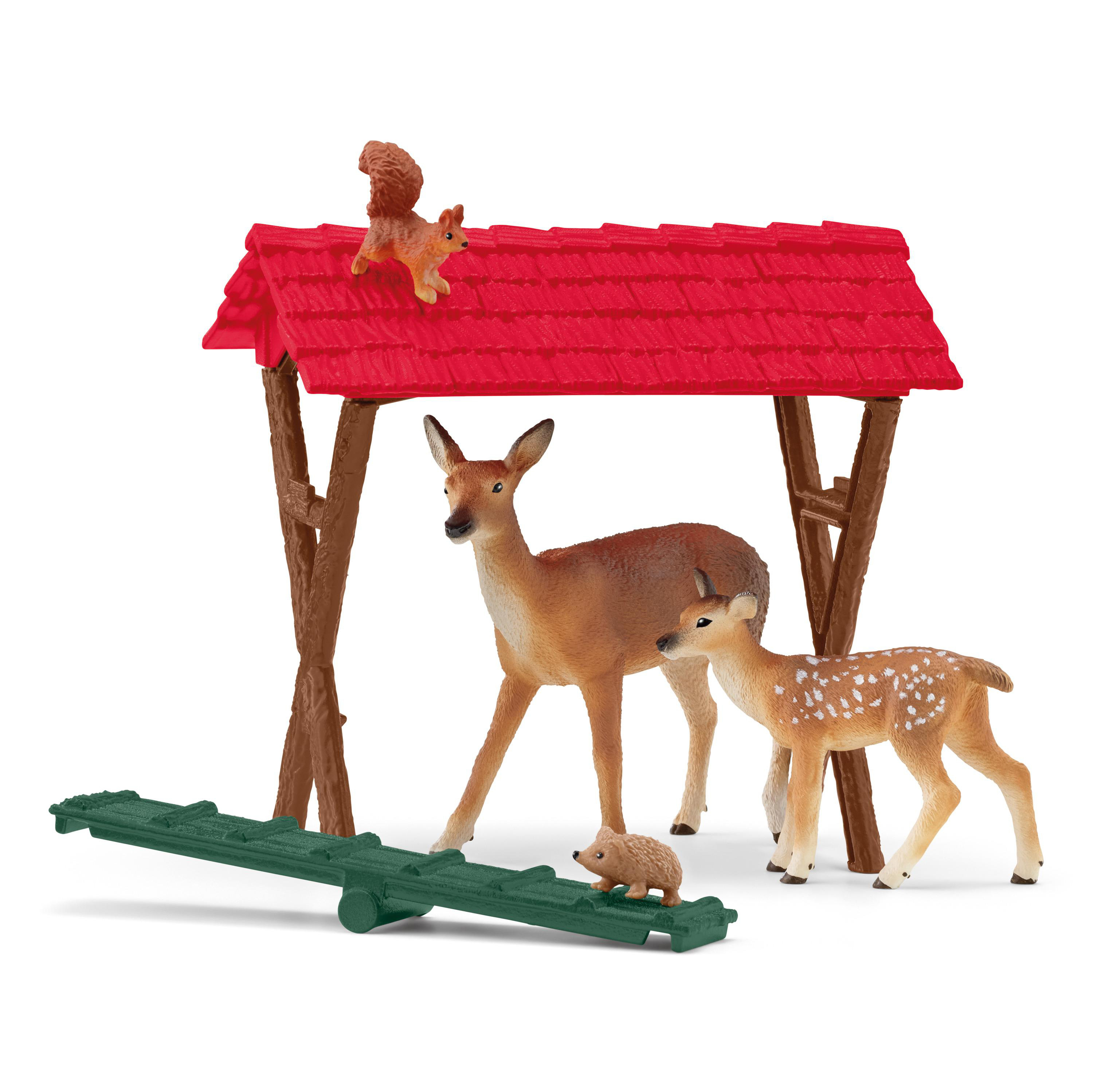 Eine Spielzeugszene mit einem Eichhörnchen auf einem rotbedachten Bauwerk, Hirschen und einem Igel.