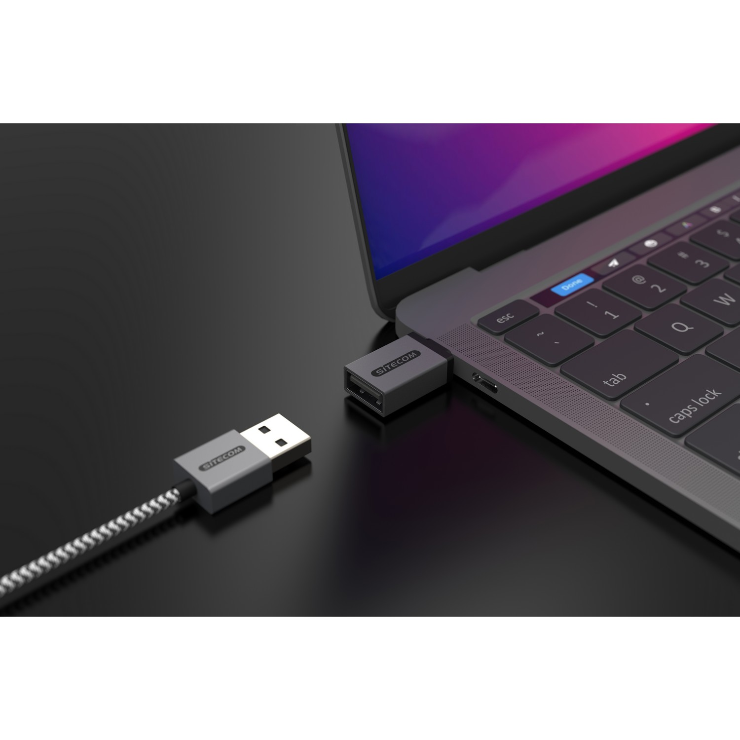 Un ordinateur portable avec un adaptateur USB-C vers USB branché et un câble USB.