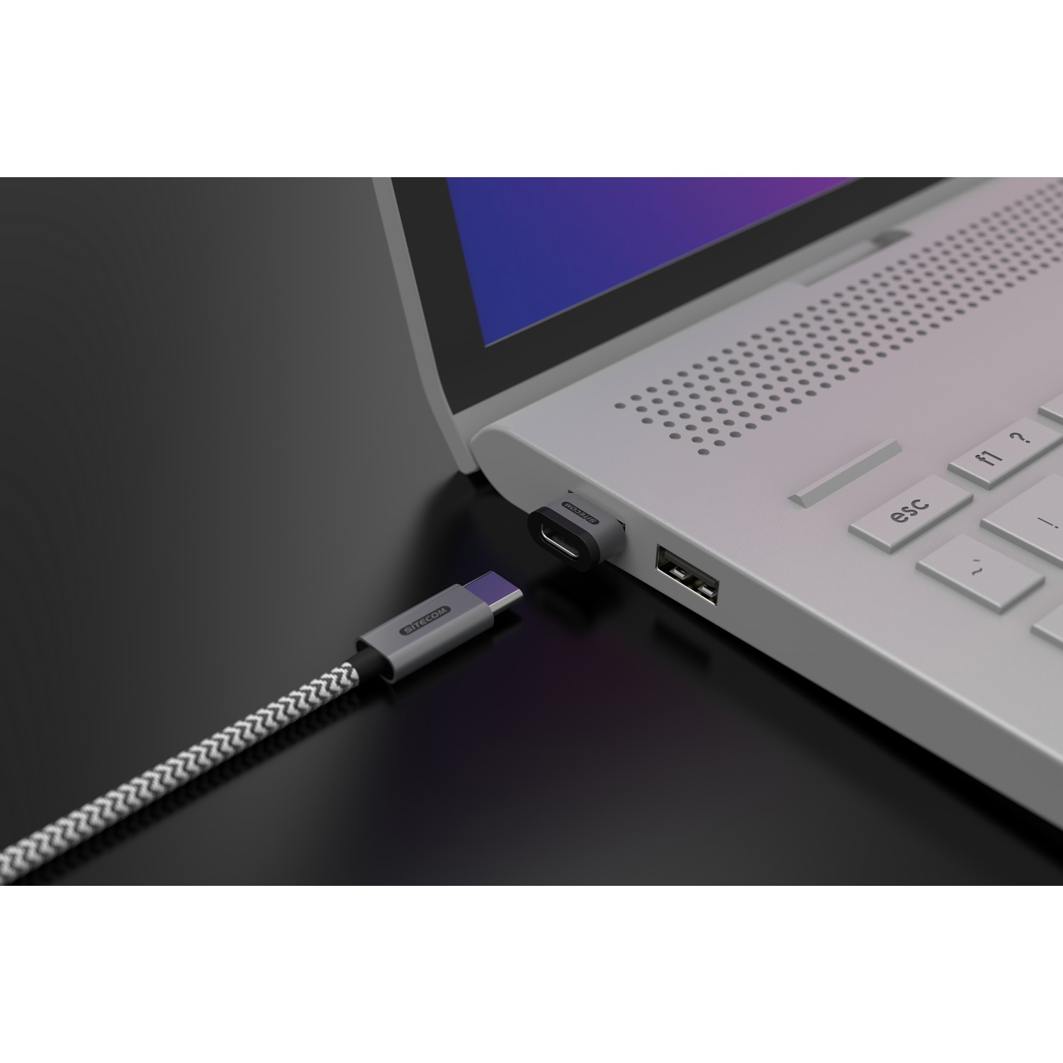 Een USB-C-kabel aangesloten op een laptop. Een USB-A-poort is open.