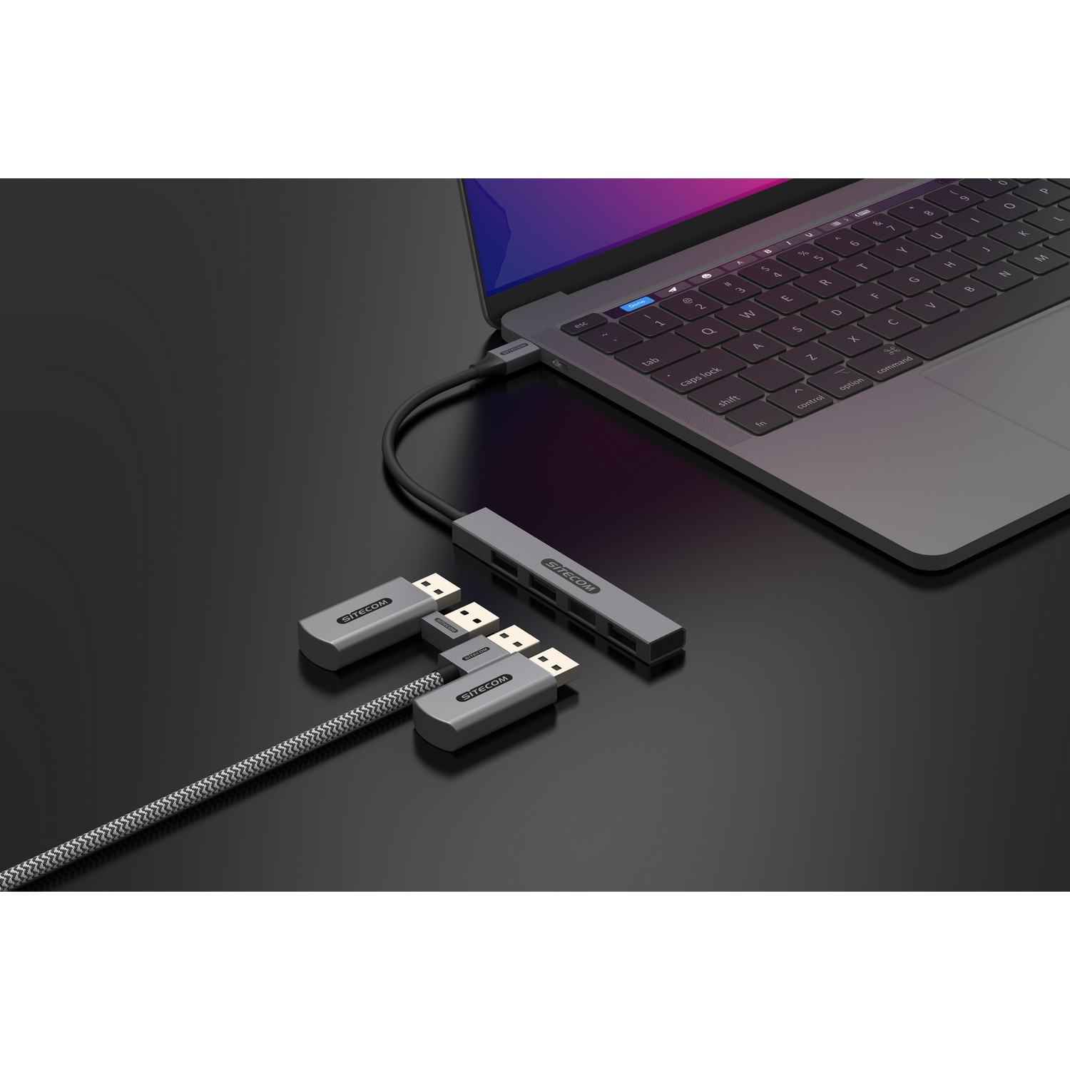 A laptop connected to a hub with USB cables and more devices.
