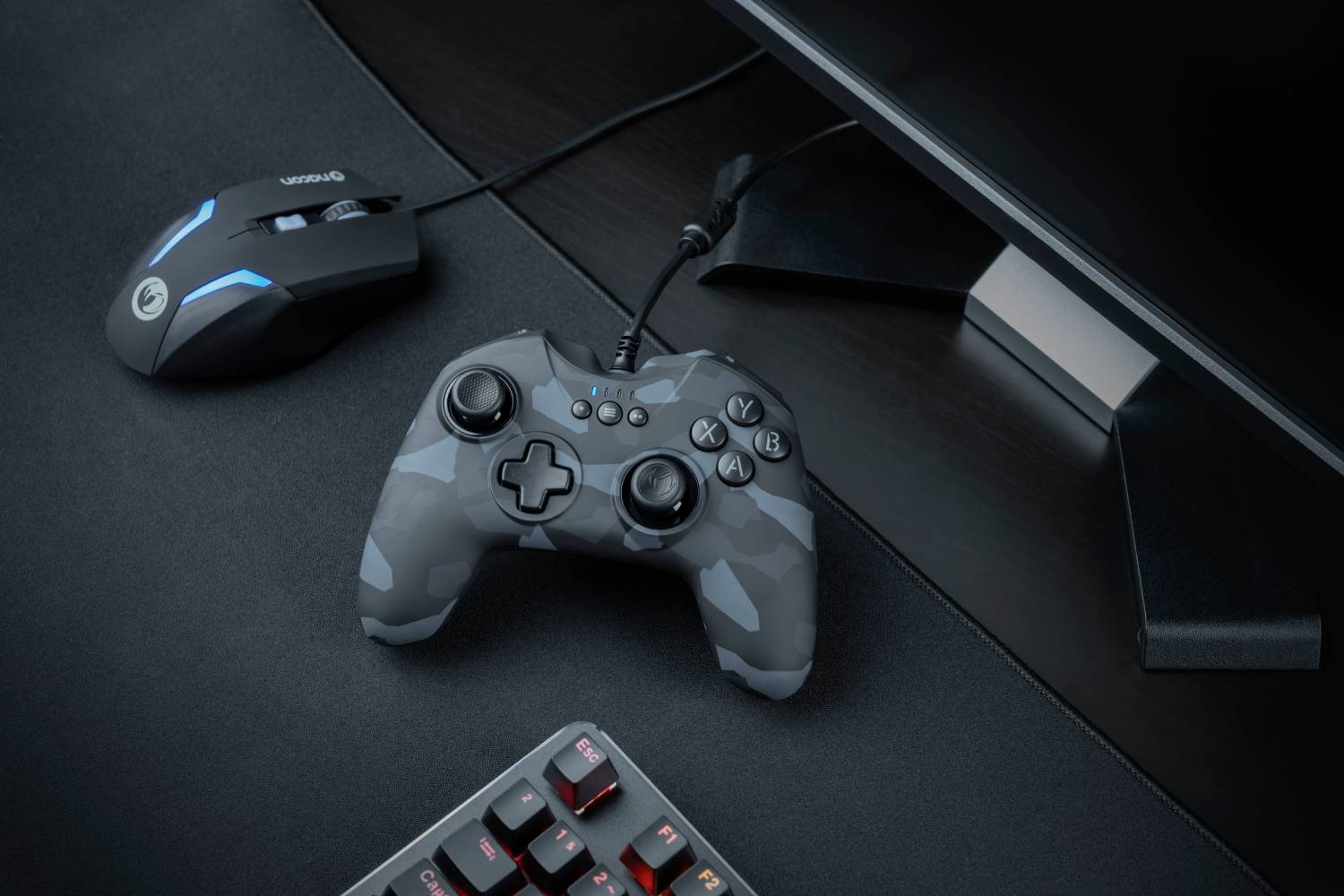 Configuración de juego: ratón negro, mando de camuflaje, teclado y monitor.