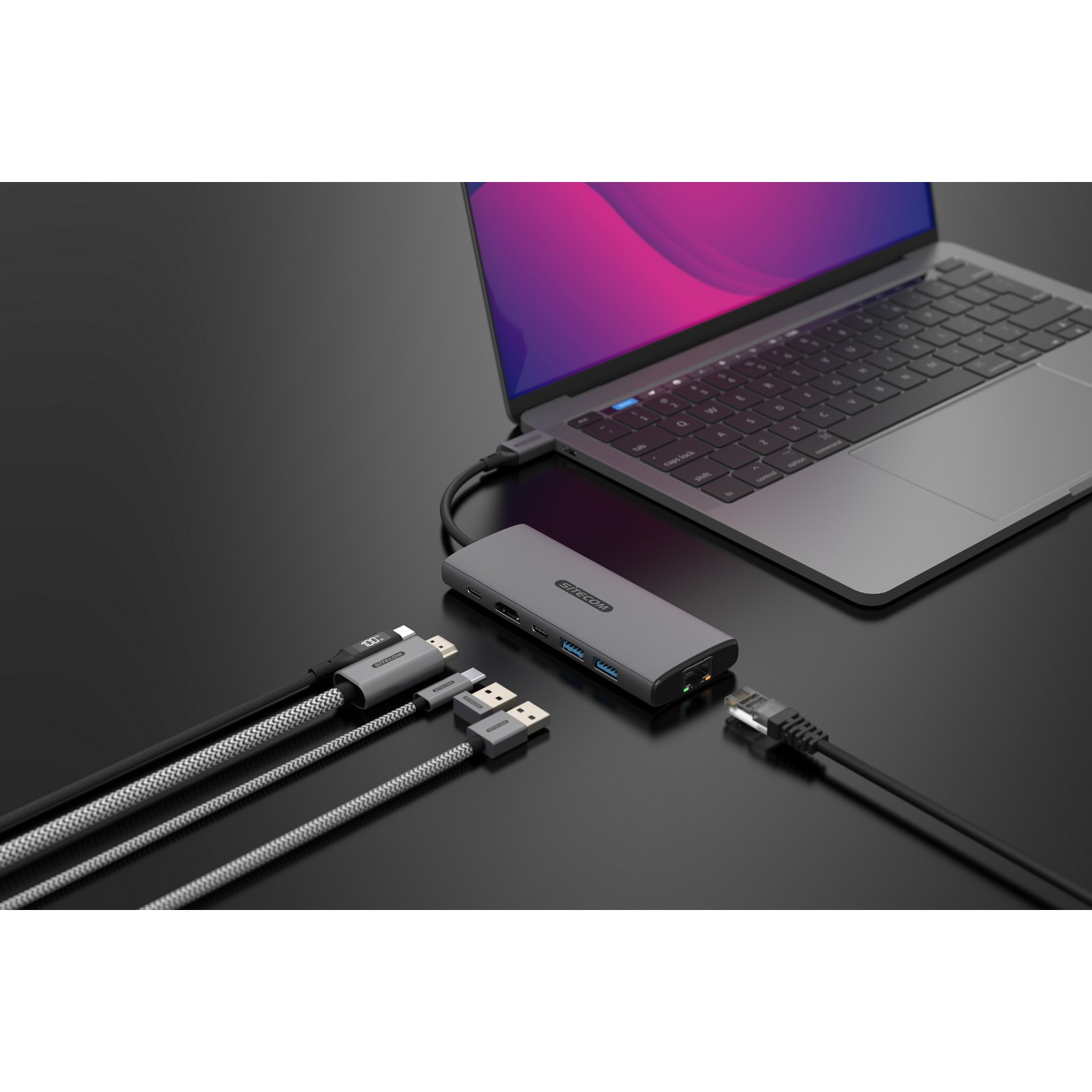 Un ordinateur portable connecté à un hub avec divers câbles pour la connectivité.