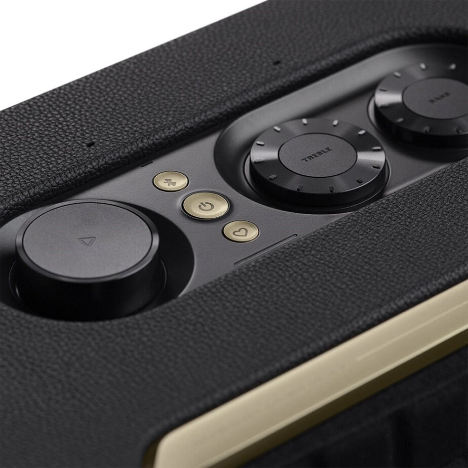 Czarny i złoty głośnik z przyciskami. Przyciski służą do regulacji głośności, tonów wysokich i niskich.