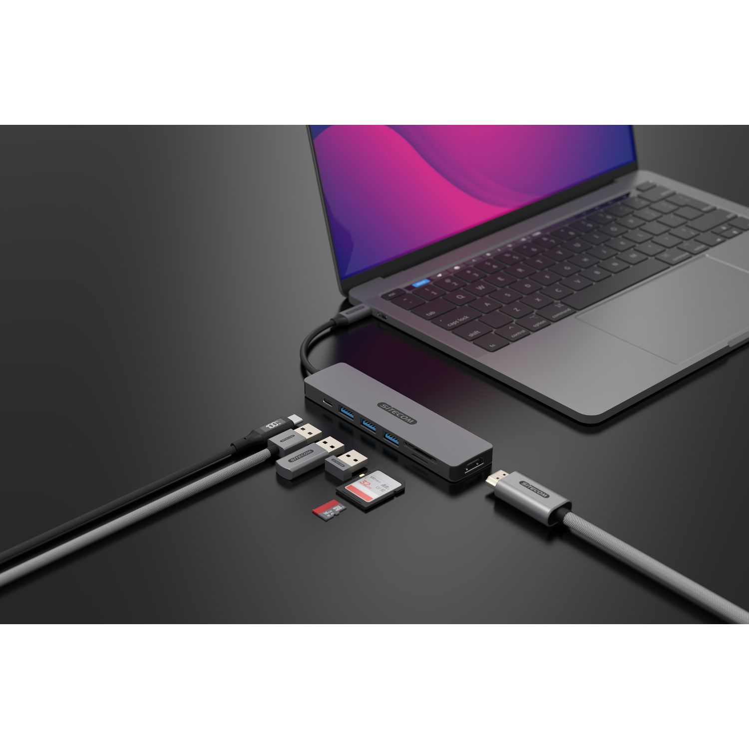 Un ordinateur portable avec des câbles et un hub connectés, et plusieurs autres appareils.