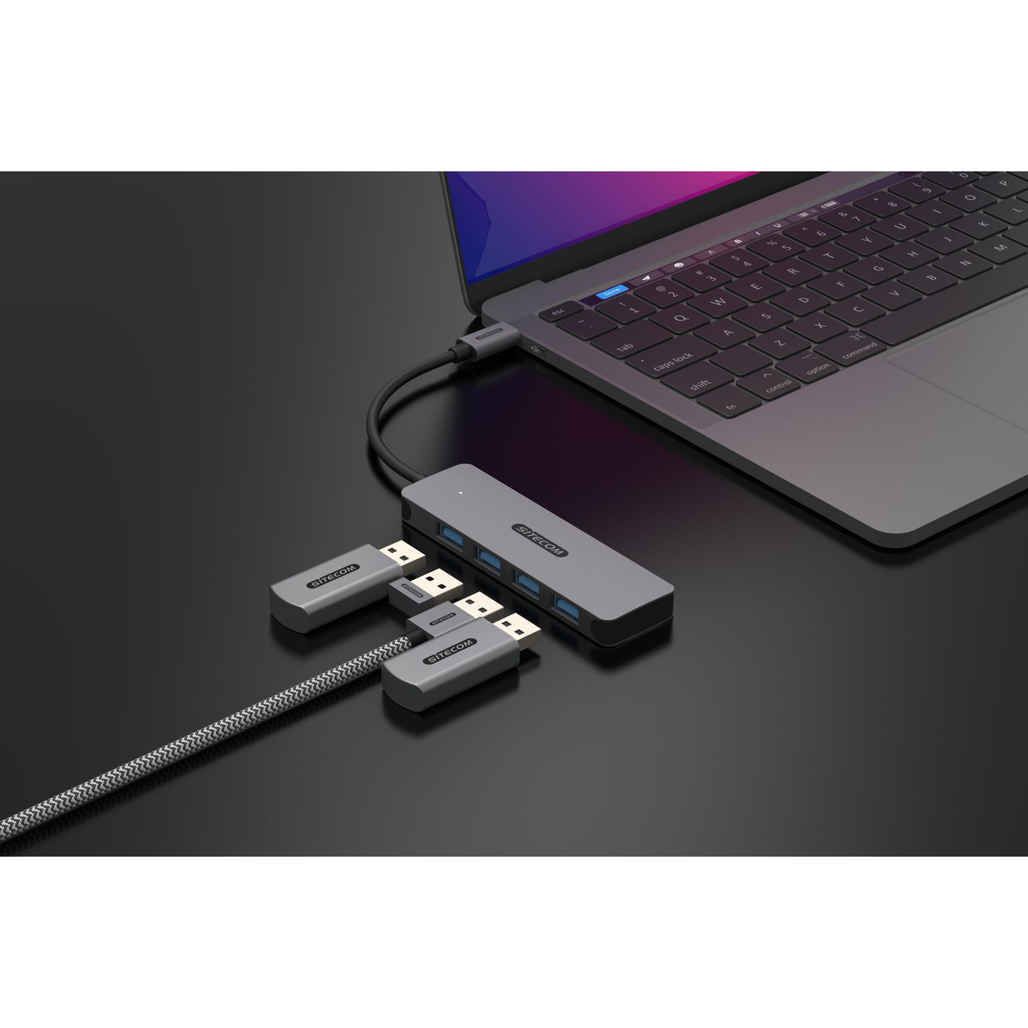 Hub USB avec appareils connectés et ordinateur portable, le tout sur une surface noire.