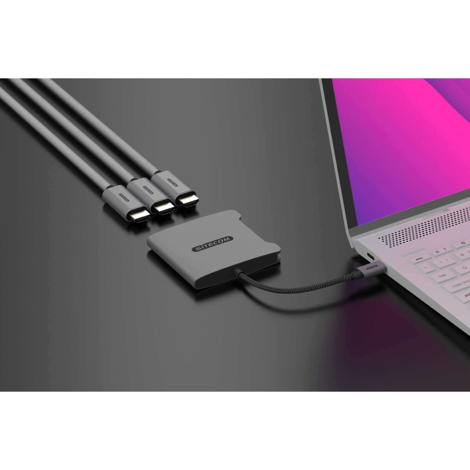 A grey hub with three cables connected to a laptop.