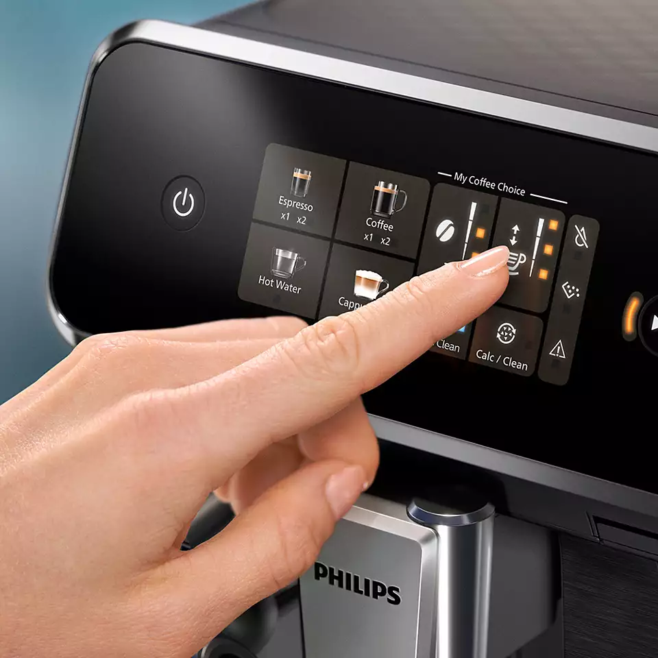 Una mano preme un touchscreen su una macchina da caffè Philips.