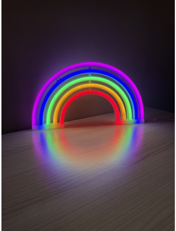 Neonowa tęcza na drewnianej powierzchni, z kolorowymi światłami.
