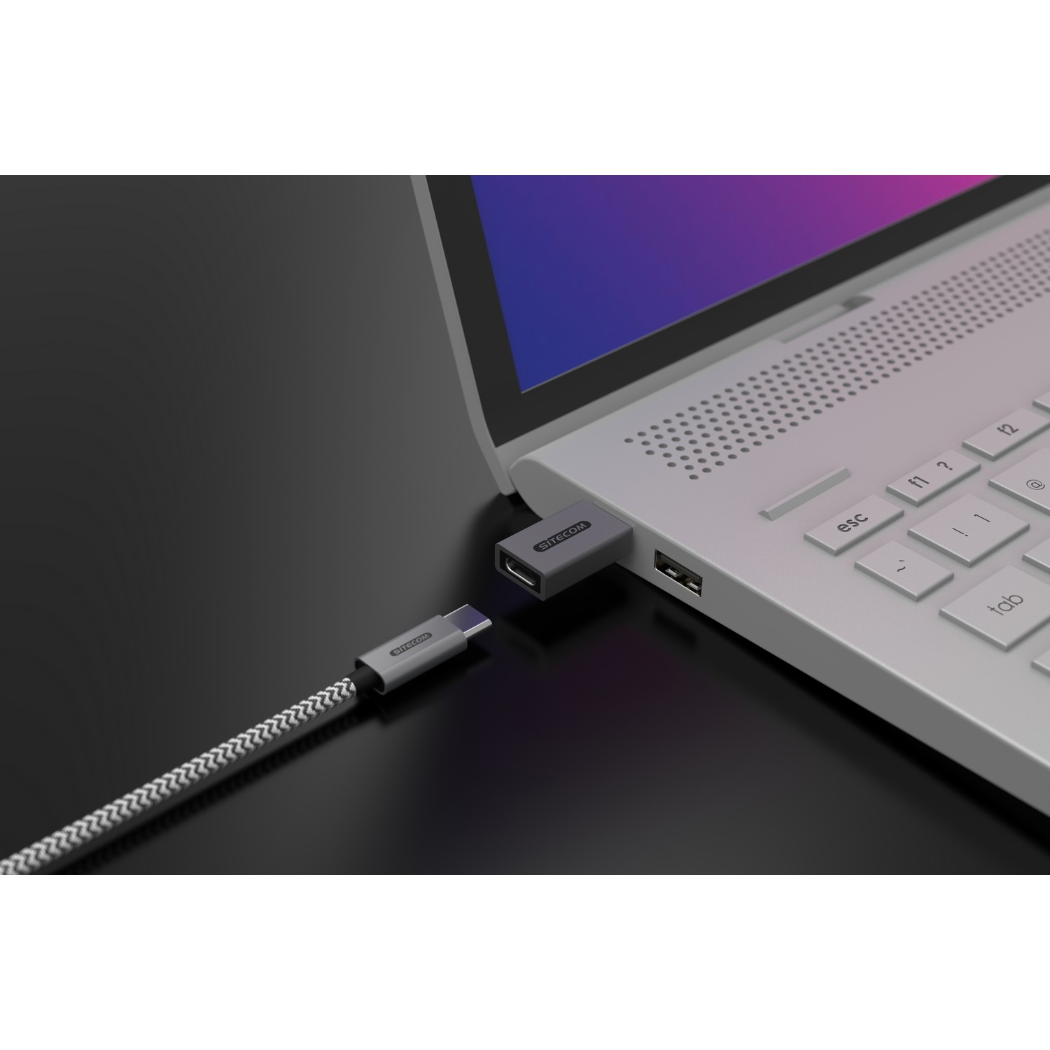 Ordinateur portable avec un adaptateur USB-C vers USB branché ; l'adaptateur est gris.