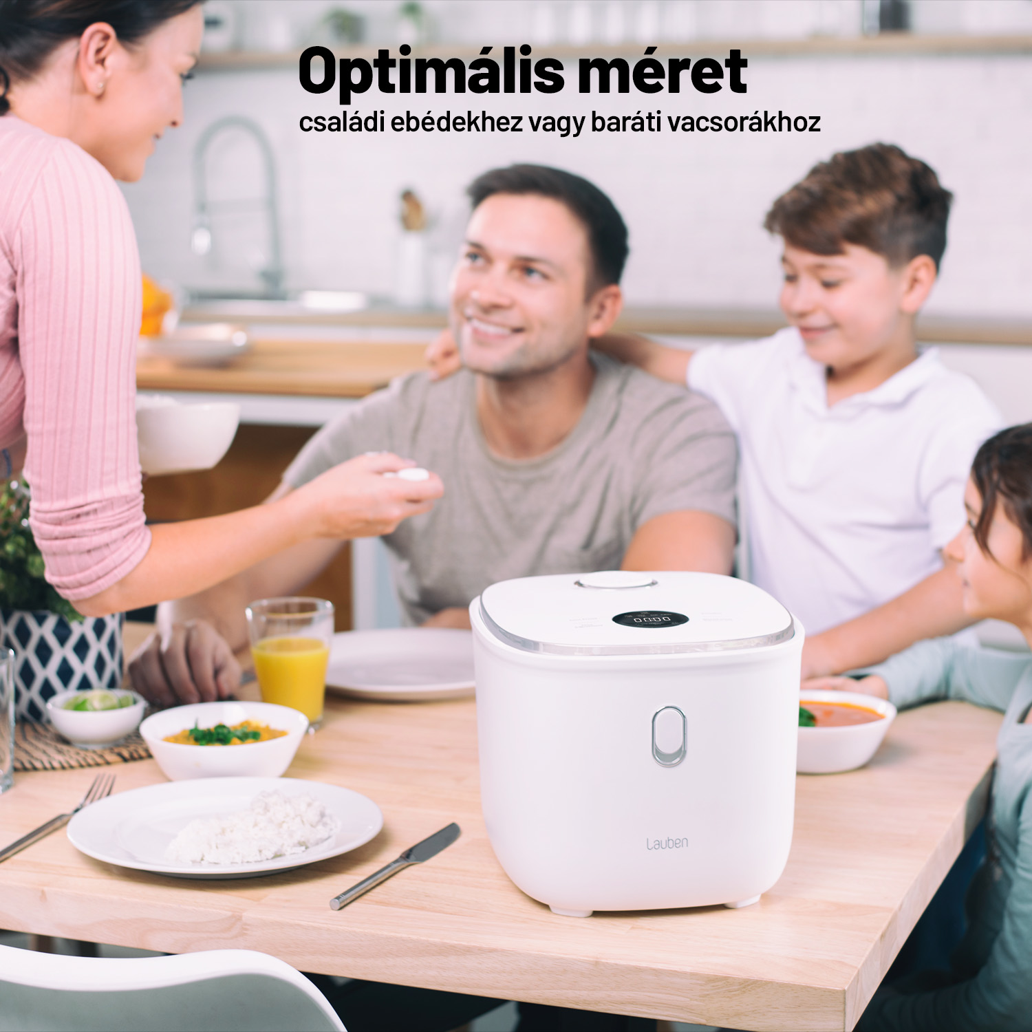 Család egy fehér rizsfőző körül. Egy nő ételt szolgál fel, egy férfi és két gyerek van jelen.