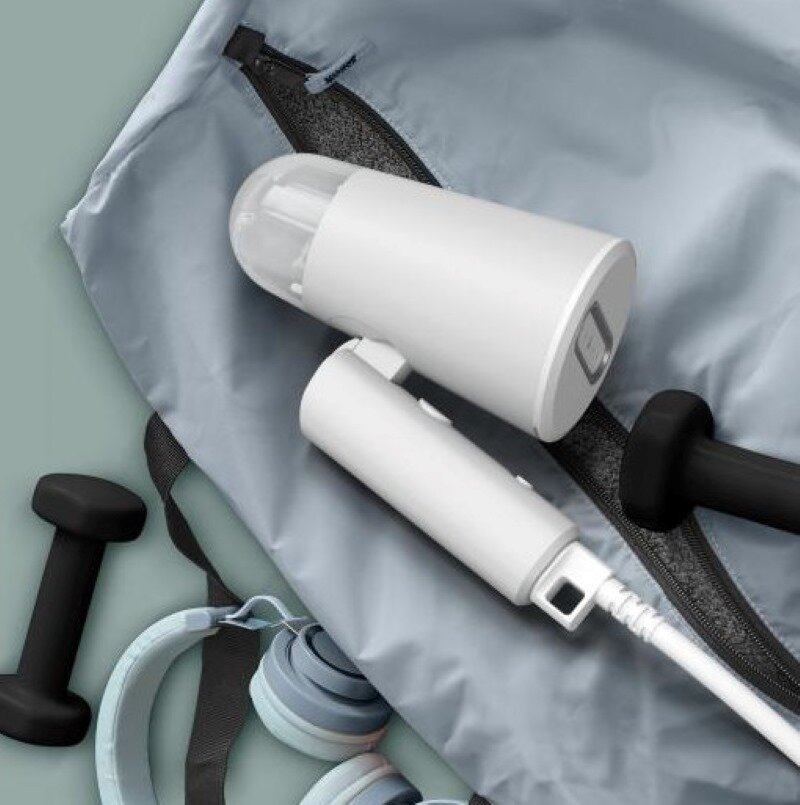 Biały przenośny oczyszczacz powietrza ze słuchawkami i innymi artykułami fitness.