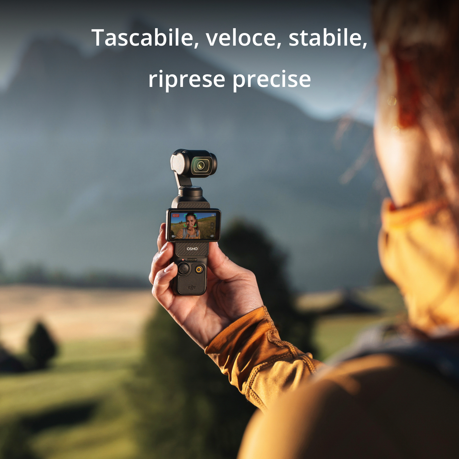 Una persona che tiene in mano una fotocamera nera. La fotocamera è puntata verso l'utente della fotocamera.