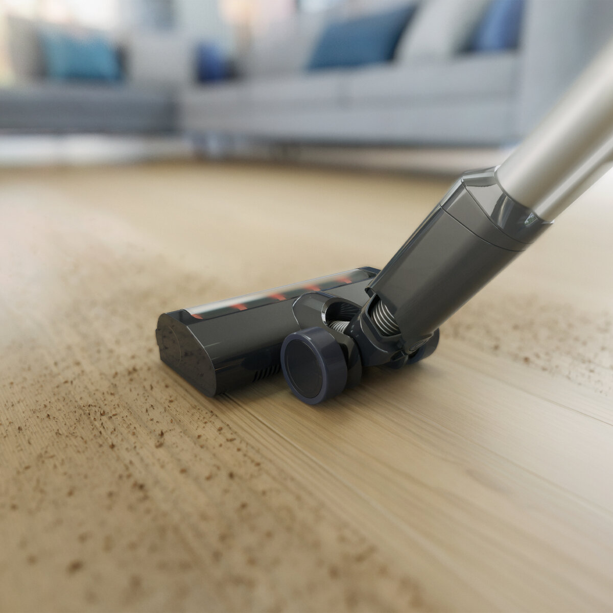 Głowica odkurzacza na drewnianej podłodze, czyszczenie. Głowica jest czarna i szara.