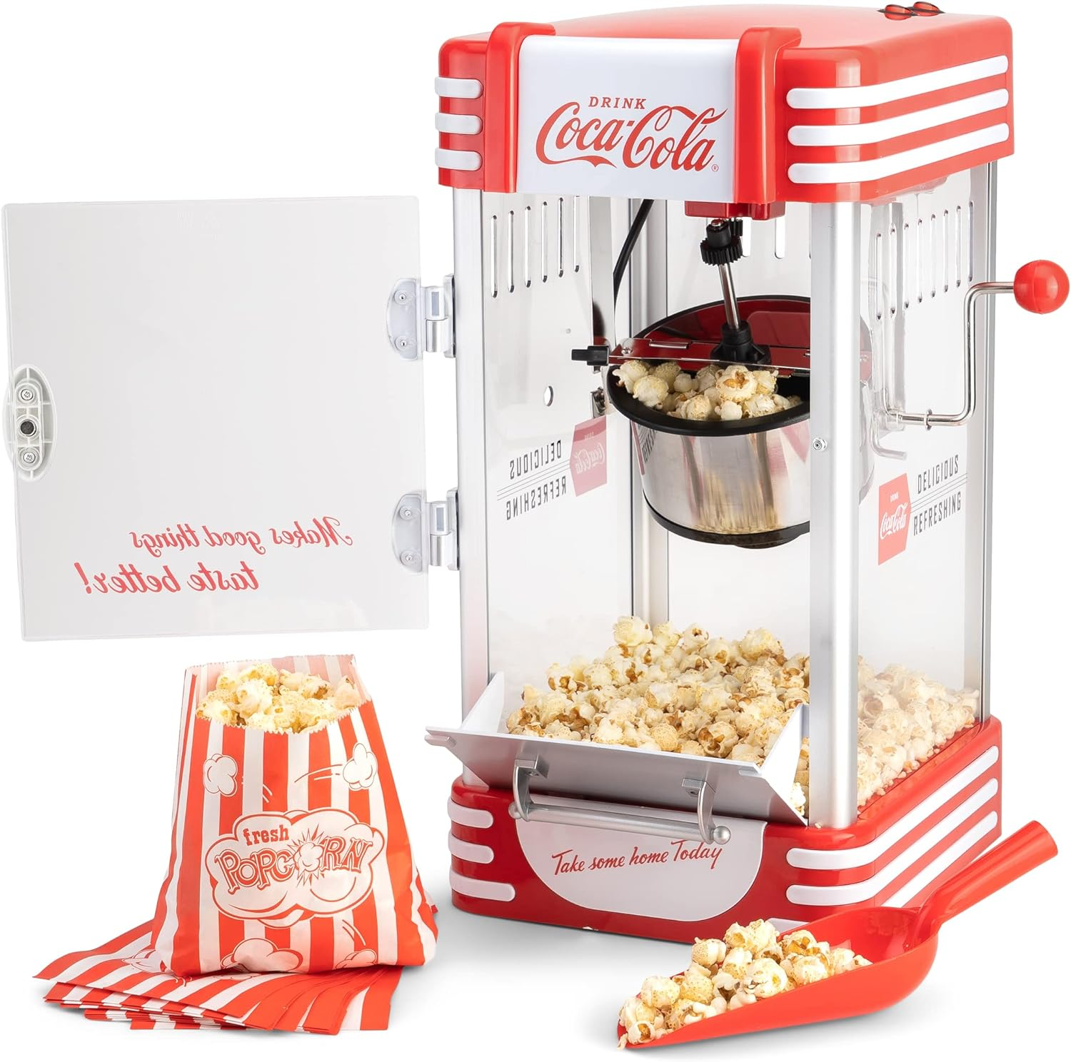 Rote und weiße Retro-Popcornmaschine mit Popcorn. Eine Tüte und ein Schöpfer sind vorhanden. Der Hintergrund ist weiß.