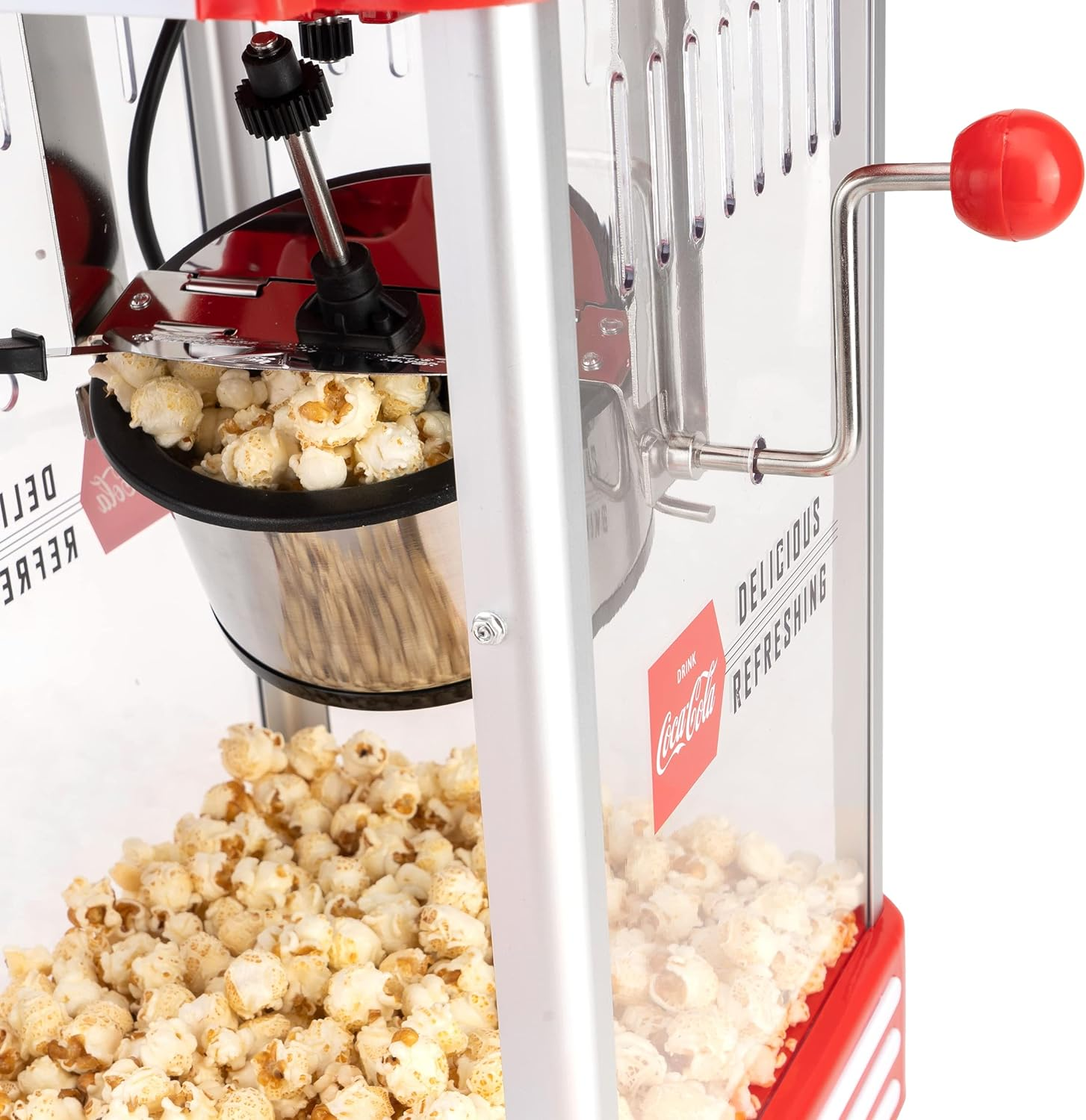 Popcornmaschine mit rotem und silbernem Design, gefüllt mit Popcorn. Coca-Cola-Branding wird gezeigt.