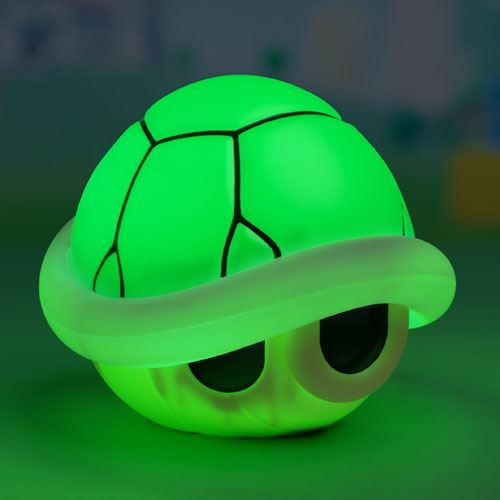 Un juguete de tortuga verde con caparazón brillante, sobre un fondo verde.