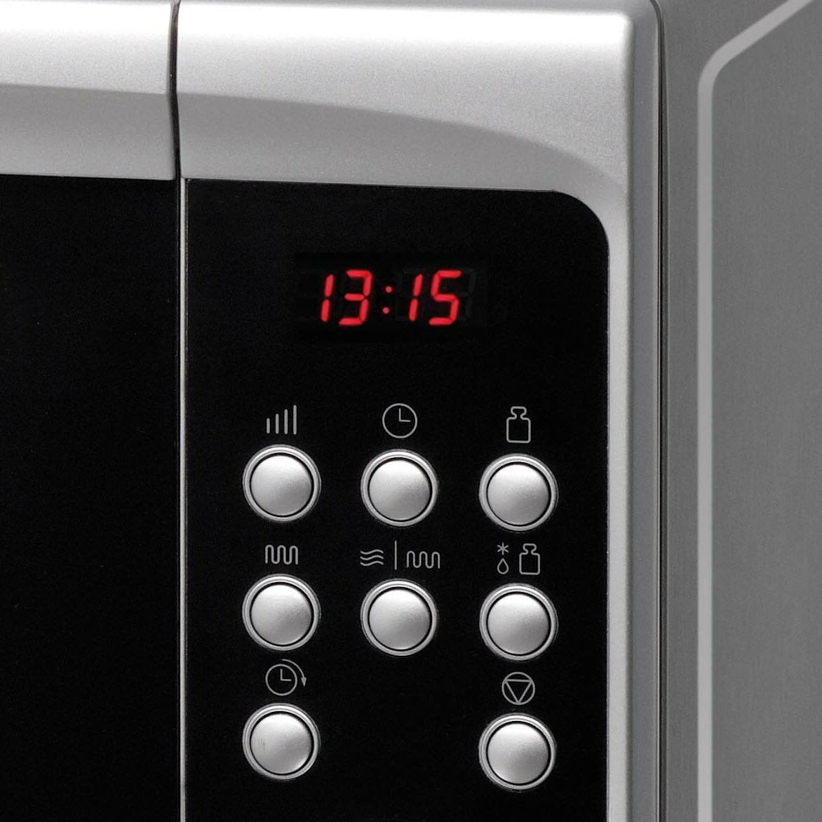Zbliżenie panelu sterowania kuchenki mikrofalowej. Wyświetlacz cyfrowy pokazuje czas, z przyciskami.