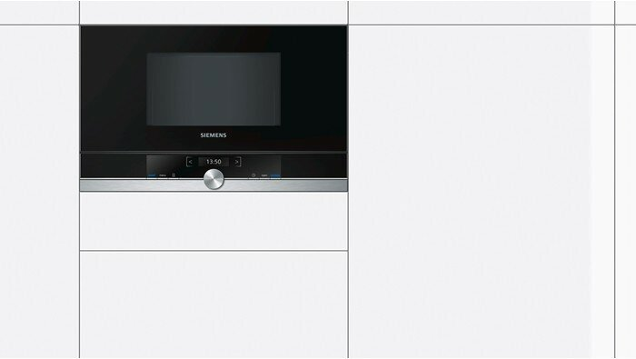 Wbudowana kuchenka mikrofalowa w białej kuchni.