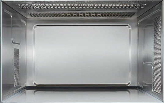 Wnętrze kuchenki mikrofalowej ze stali nierdzewnej, puste, z prostokątnym zagłębieniem.