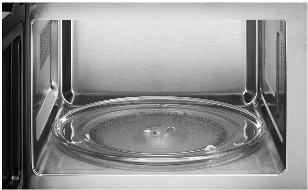 Wewnątrz kuchenki mikrofalowej. Przezroczysty szklany talerz znajduje się na dole, ze ścianami ze stali nierdzewnej.