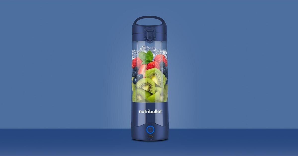 Niebieski blender Nutribullet wypełniony owocami i lodem. Na niebieskim tle.