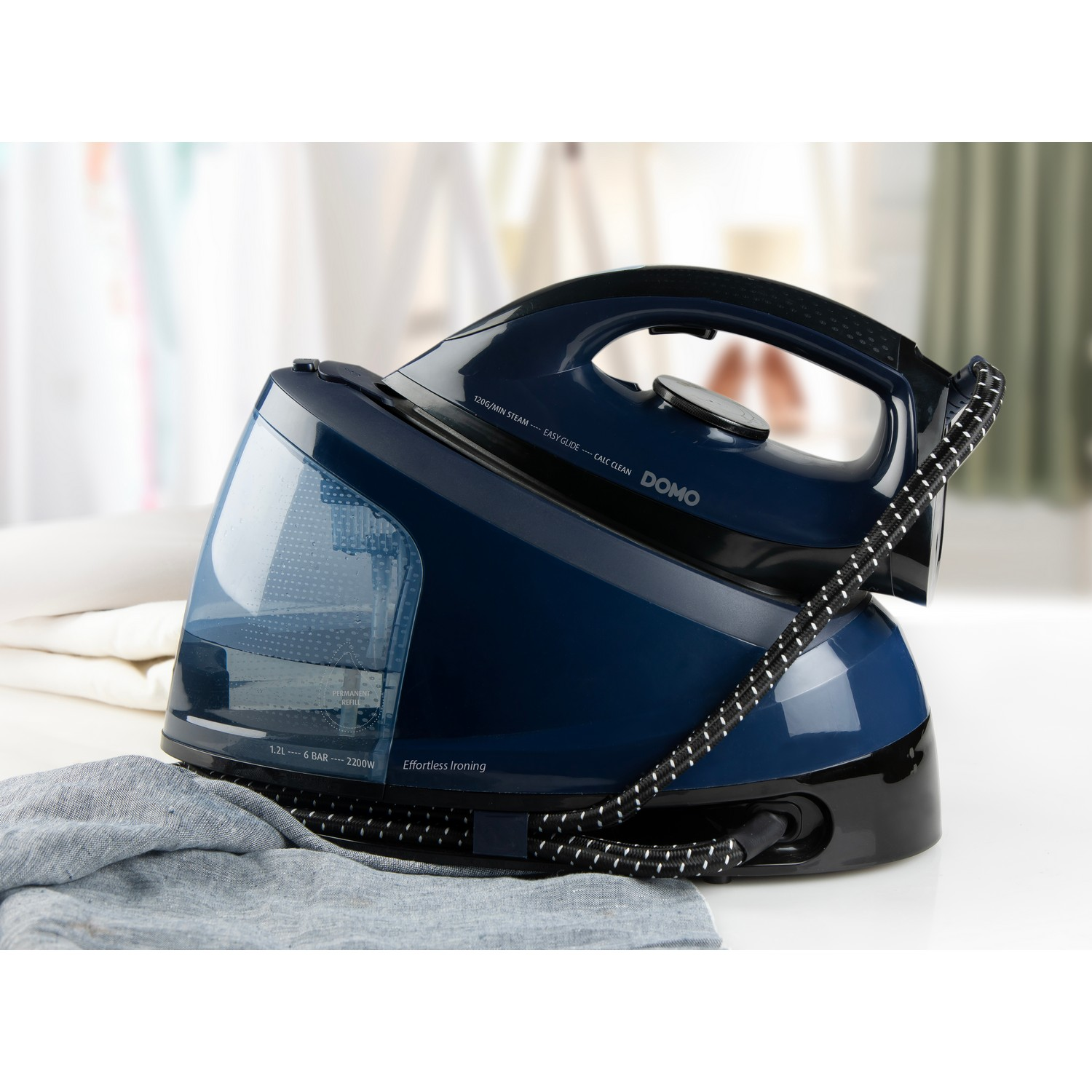 A blue and black DOMO steam iron with a water tank and a gray cloth.