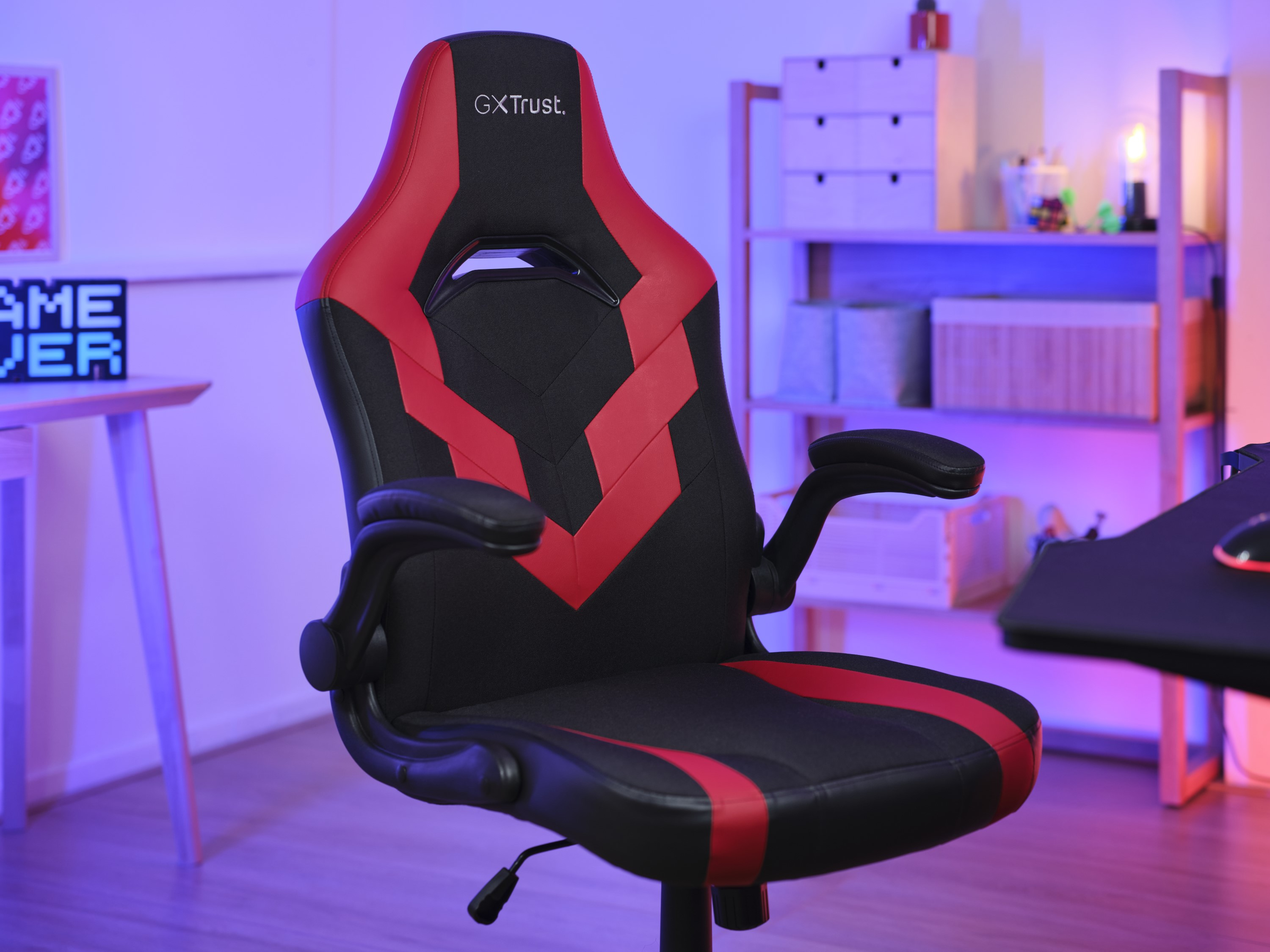 Chaise gaming avec des accents rouges et noirs. Panneau Game over en arrière-plan.