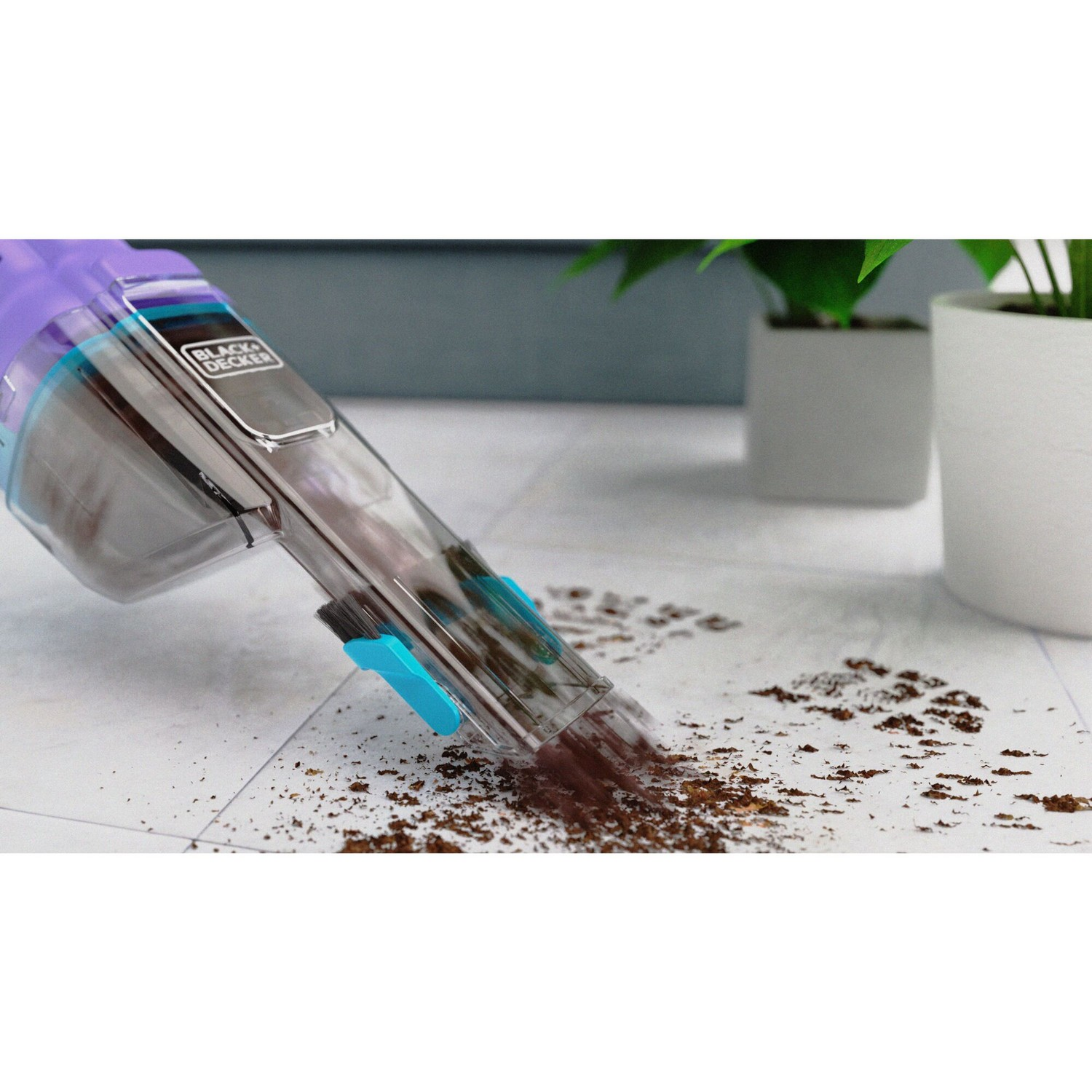 A hand vac cleaning up dirt on a tiled floor with a brush attachment.