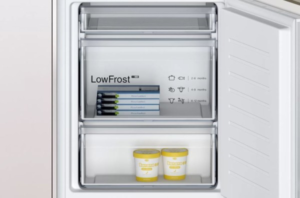 Interior de un refrigerador con cajones congeladores y helado.