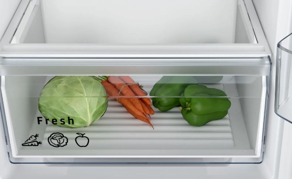 Cajón de refrigerador con col, zanahorias y pimientos. Texto: Fresco, iconos de verduras.
