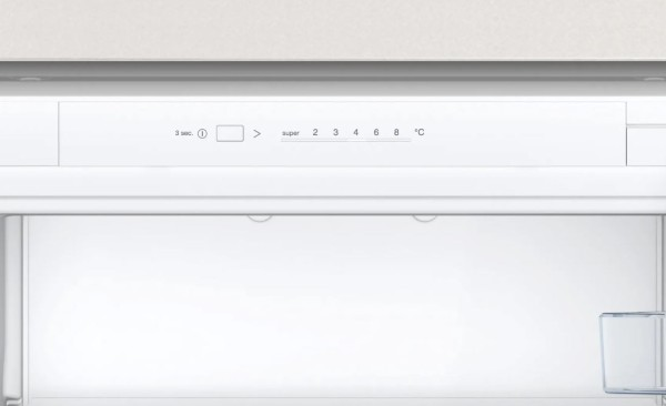 Panel de control del refrigerador con ajustes de temperatura. El refrigerador abierto revela un interior vacío.