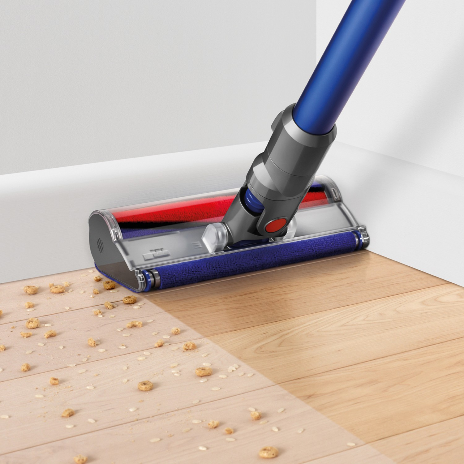 Stofzuiger die een houten vloer schoonmaakt. Er ligt wat vuil op de vloer.