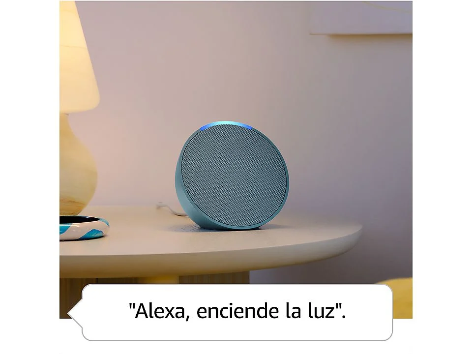 Altavoz inteligente azul sobre mesa, con bocadillo "Alexa, enciende la luz".