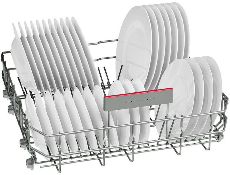 Panier de lave-vaisselle avec des assiettes blanches disposées pour le lavage.