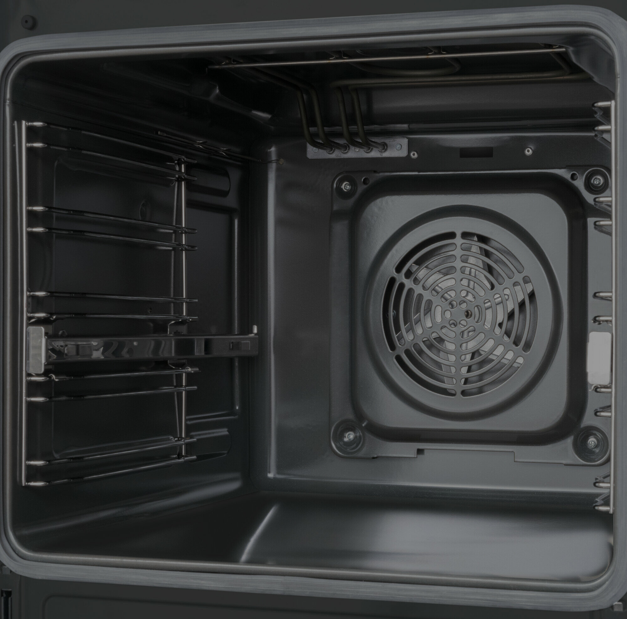 Wnętrze piekarnika, ciemnoszare wnętrze z wentylatorem i rusztami.