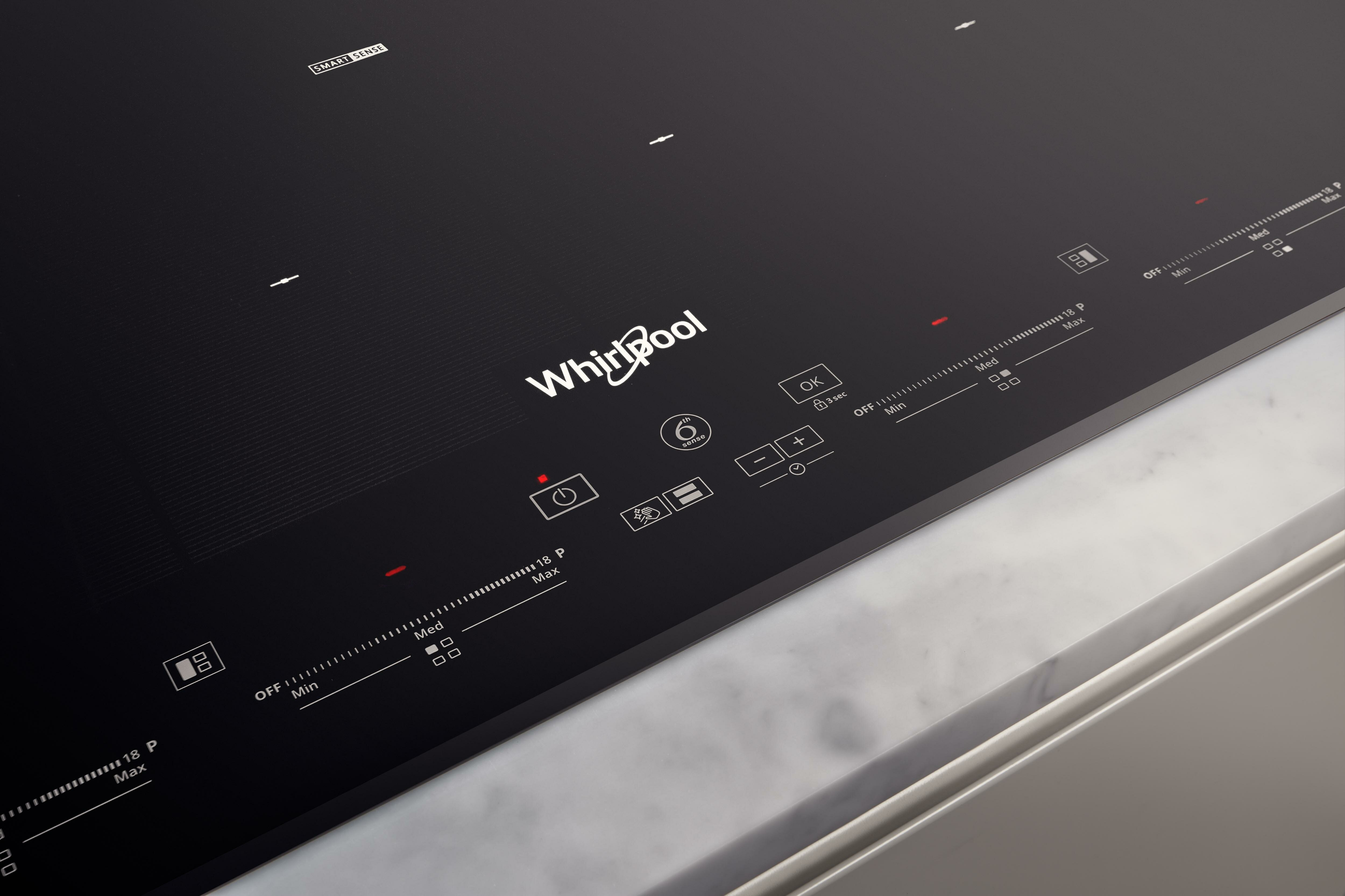 Zbliżenie na czarną płytę indukcyjną Whirlpool. Panel sterowania z symbolami i przyciskami.